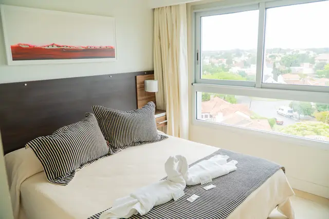 Dormitorio con ventanal en Apart Hotel Sotavento Miramar